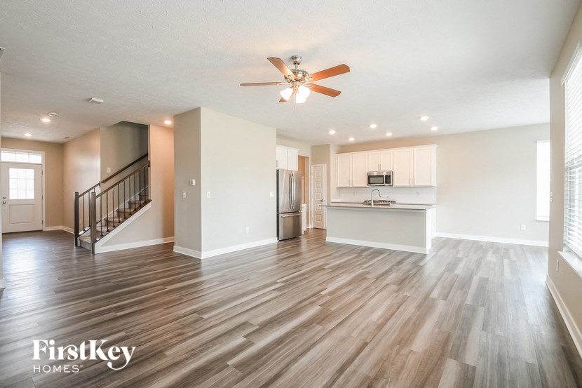 an open living room and kitchen with a ceiling fan