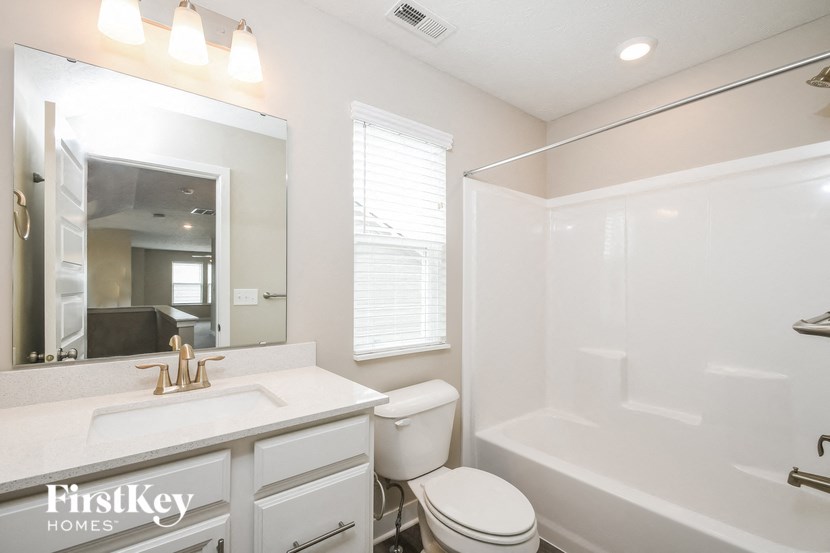 a white bathroom with a white toilet and a sink