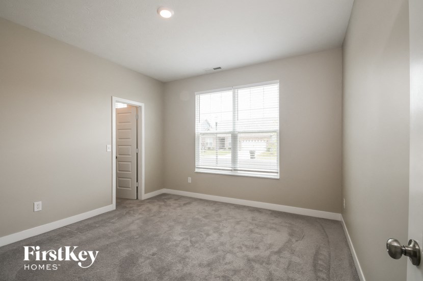 an empty room with a window and a door to a closet