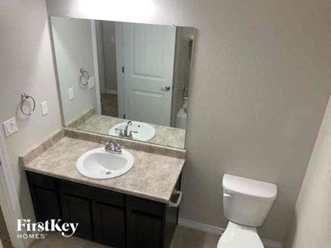 a bathroom with a sink toilet and a mirror
