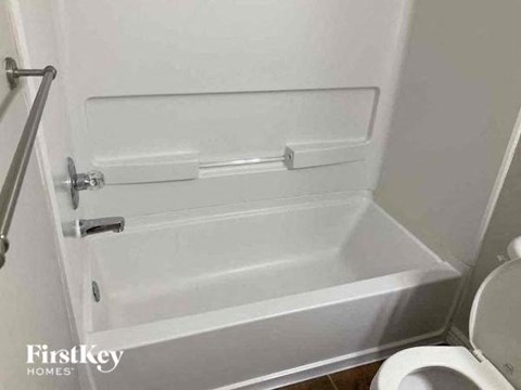 a bathroom with a white tub and a toilet