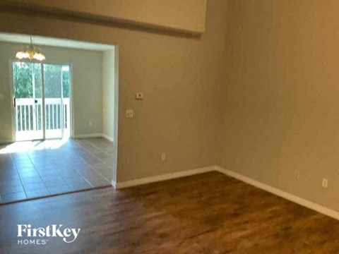 an empty living room with a wood floor and a doorway