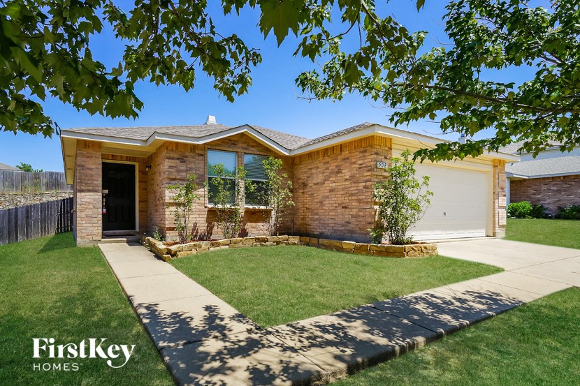 the front of a brick house with a lawn