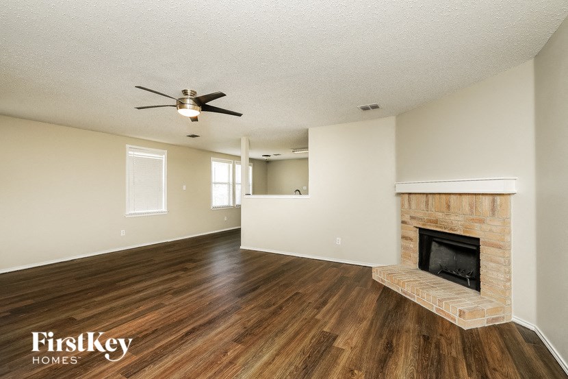 a living room with a fireplace and a ceiling fan