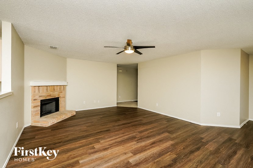 a living room with a fireplace and a ceiling fan