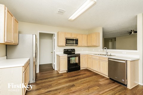 a kitchen with wooden floors and wooden cabinets