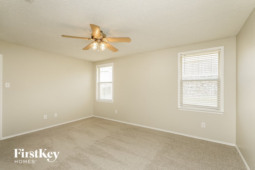 a bedroom with a ceiling fan and a window