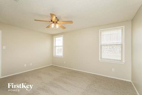 a bedroom with a ceiling fan and a window