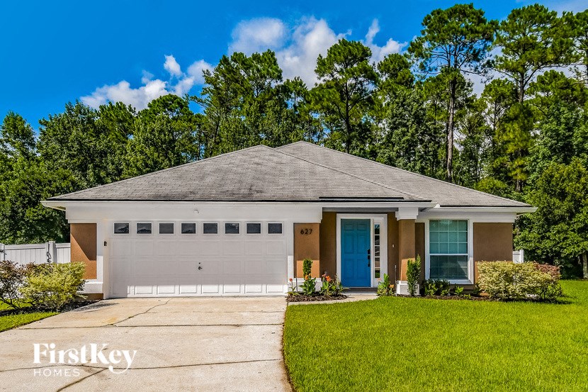 a home with a blue door and a lawn