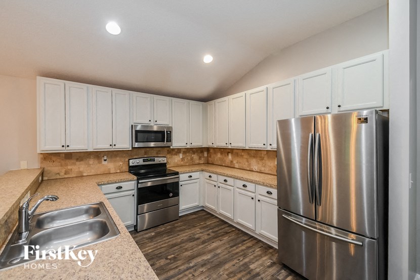 a kitchen with white cabinets and stainless steel appliances
