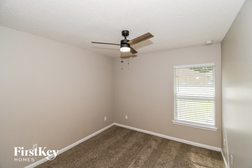 a bedroom with a ceiling fan and a window