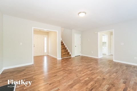 A spacious room with wooden floors and white walls.