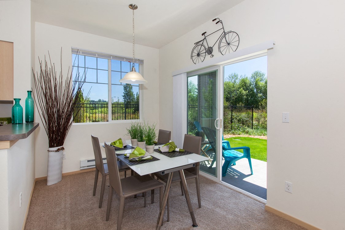 a dining room with a table and chairs and a sliding glass door