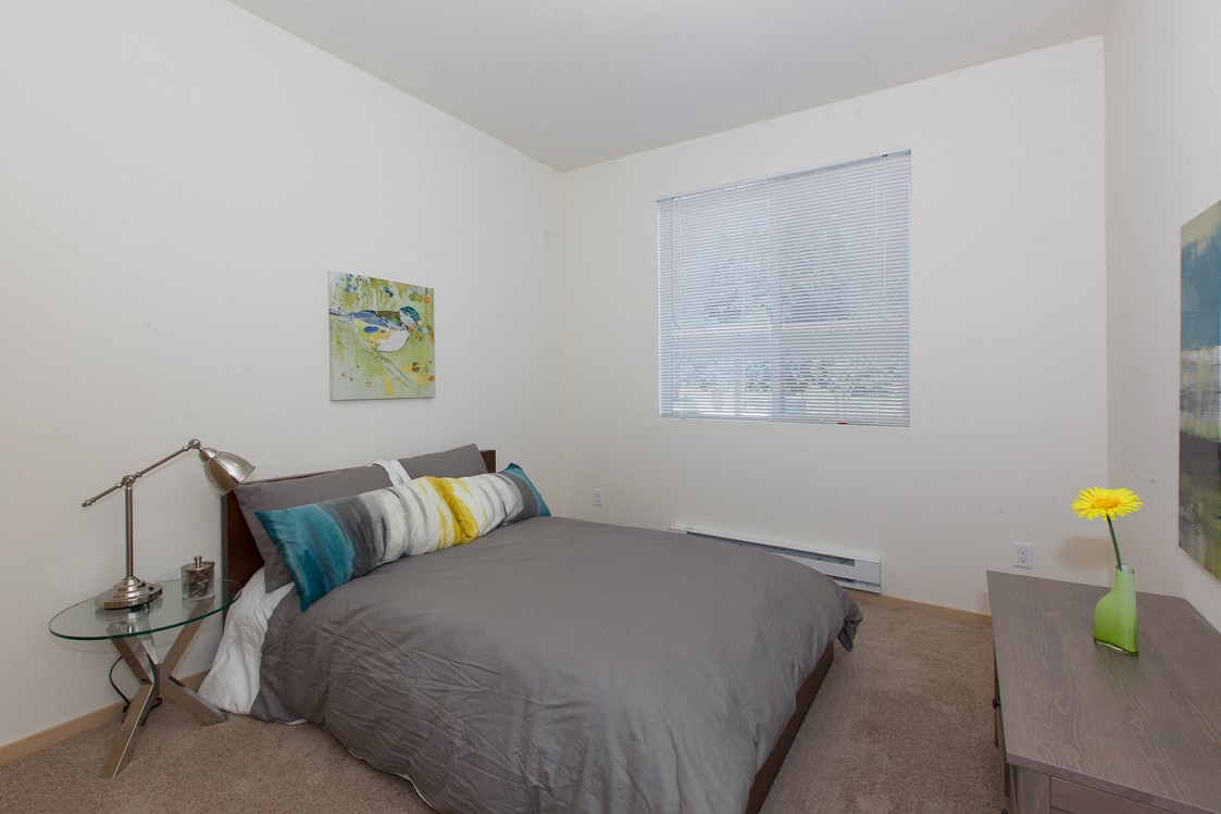 a bedroom with a bed and a desk and a window