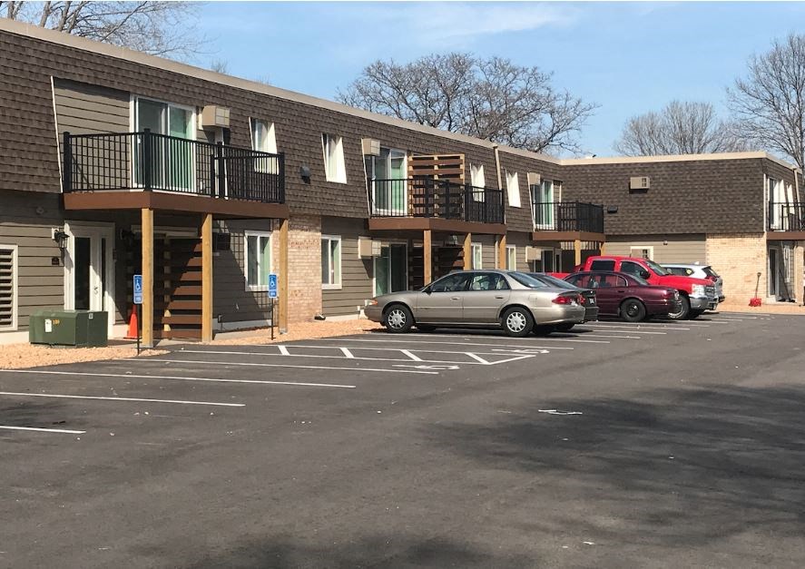 a parking lot filled with cars in front of a building