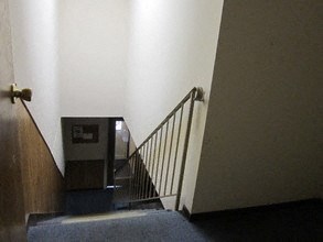 a stairwell with a metal railing and a door