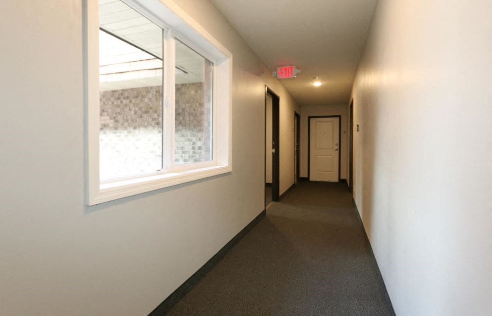 a long hallway with a large window and a door