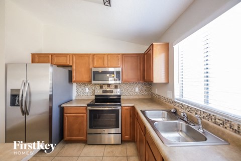 A kitchen with wooden cabinets and a stainless steel refrigerator.