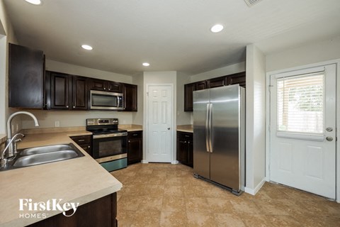 a kitchen with a stainless steel refrigerator and a sink