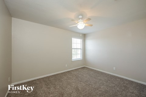 a bedroom with carpet and a ceiling fan