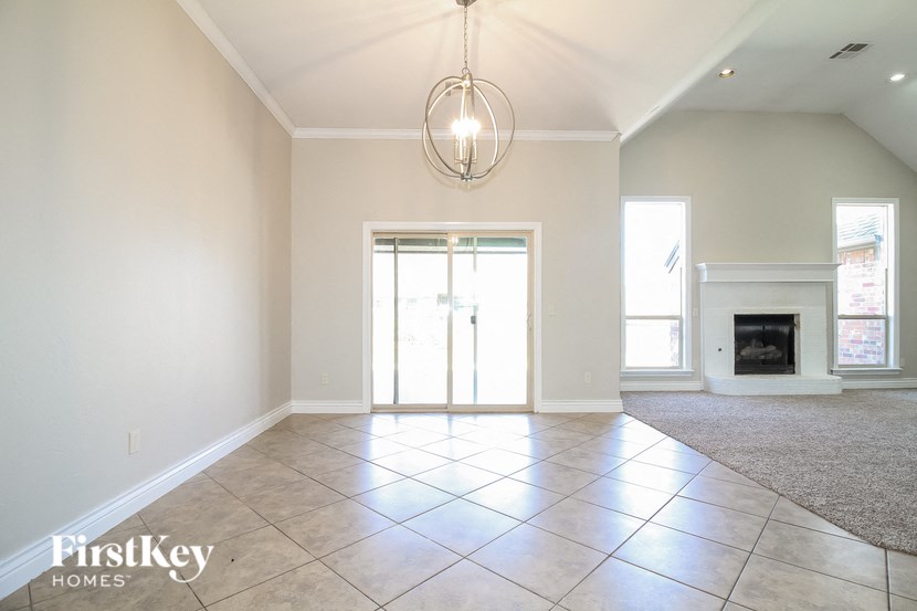an empty living room with a fireplace and a chandelier