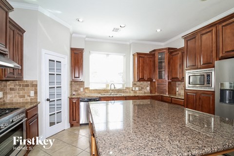 a kitchen with wood cabinets and a granite counter top