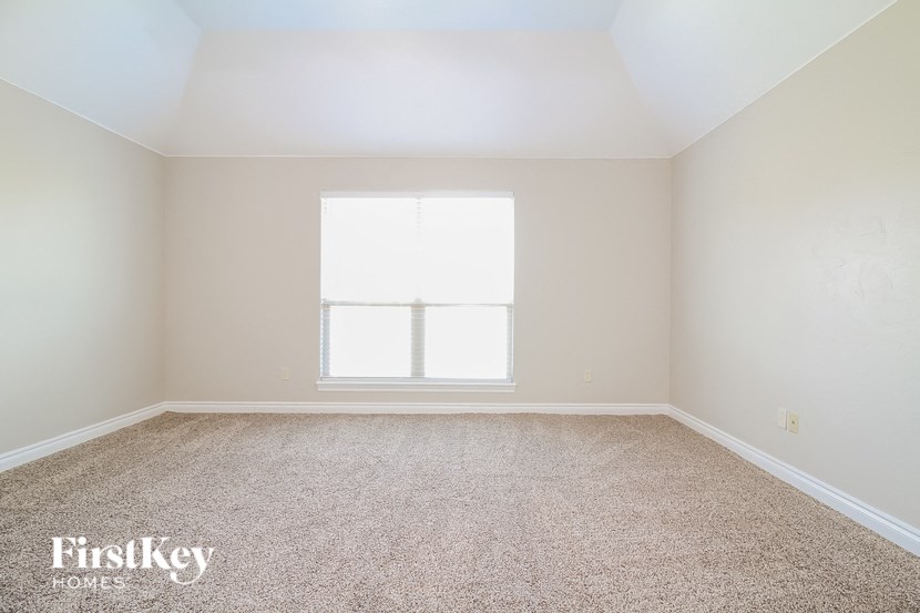 a empty room with carpet and a window