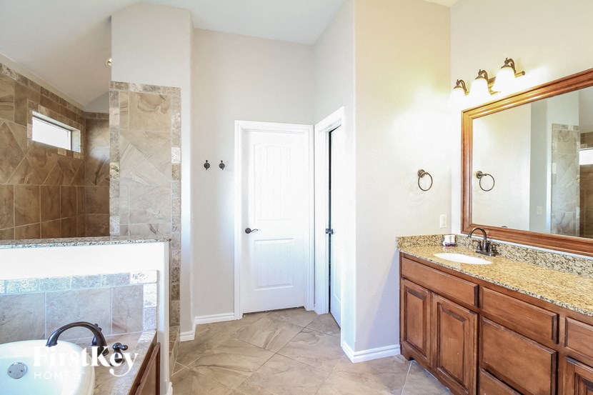 a bathroom with a shower and a sink and a mirror