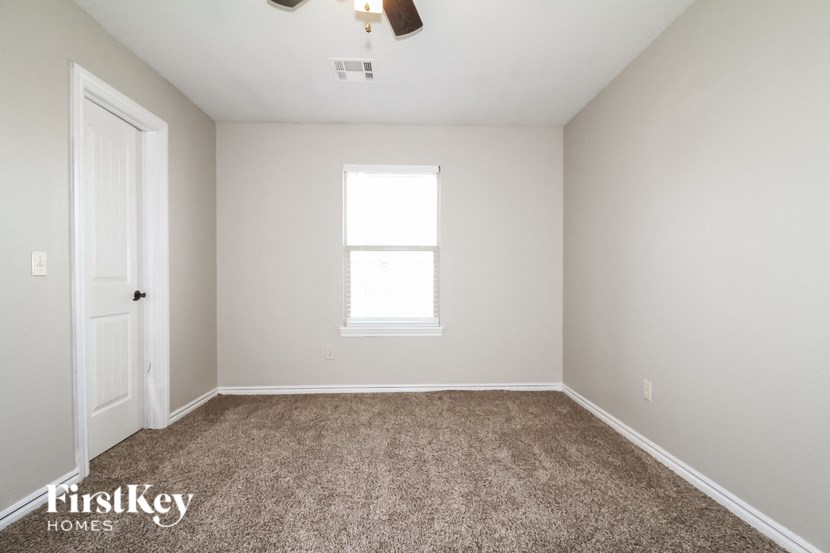a empty room with carpet and a window