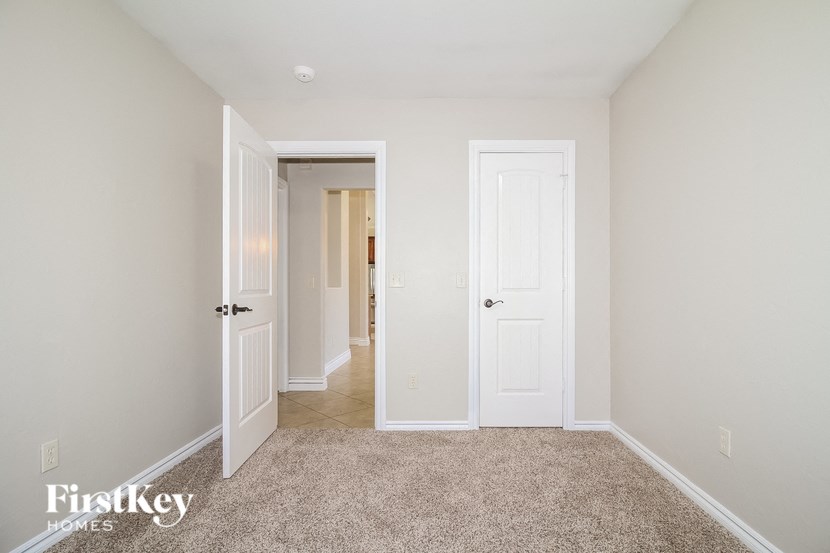 a bedroom with two doors and a carpeted floor
