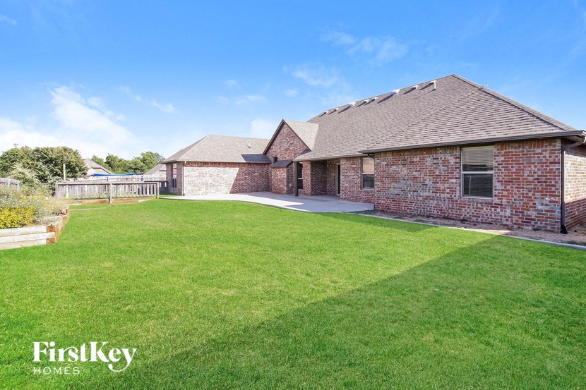 a backyard with a lawn and a brick house