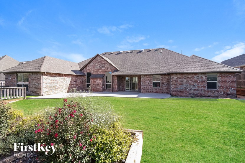 a brick house with a lawn and a garden