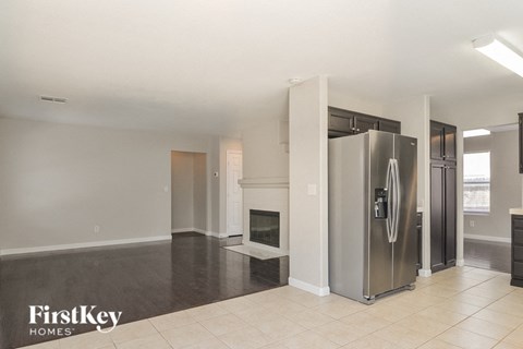 A modern kitchen with a stainless steel refrigerator and a fireplace.