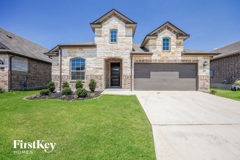 a large brick house with a garage and a lawn