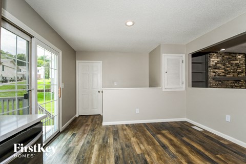 a living room with wood flooring and a door to a balcony
