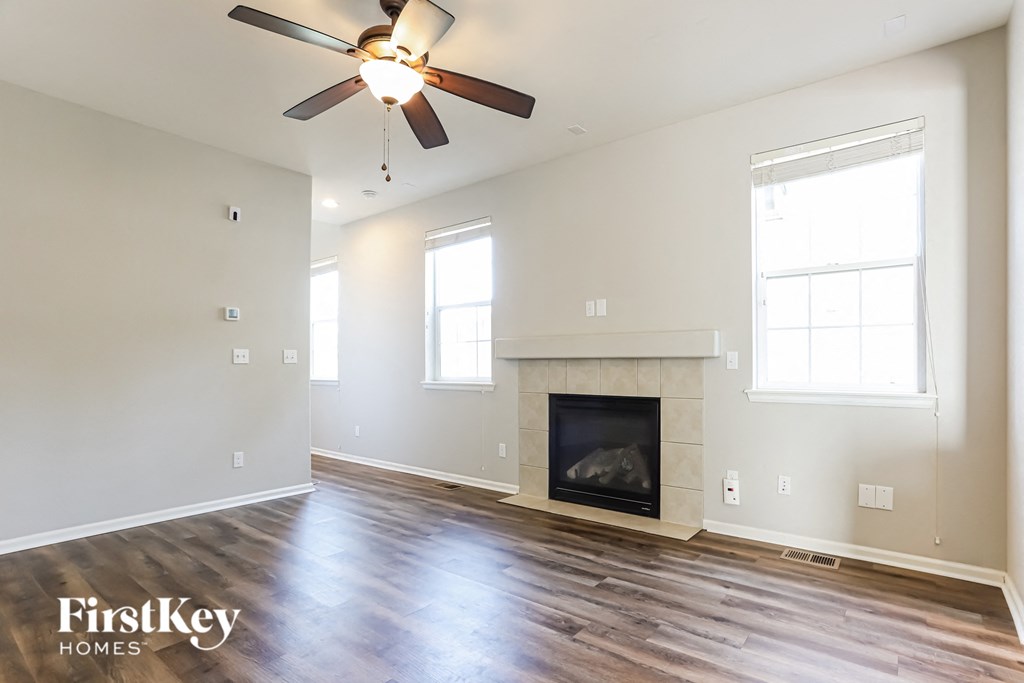 a living room with a fireplace and a ceiling fan