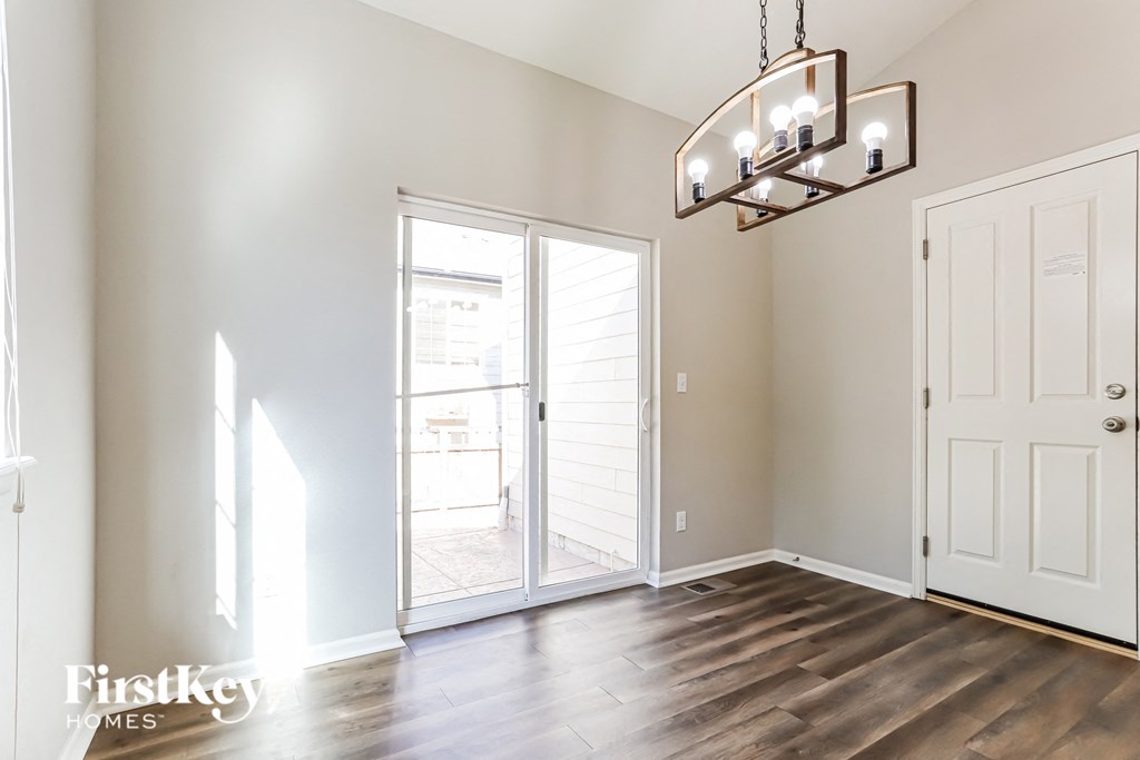 a living room with a door to a balcony and a chandelier