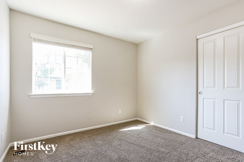 a bedroom with carpet and a window and a door