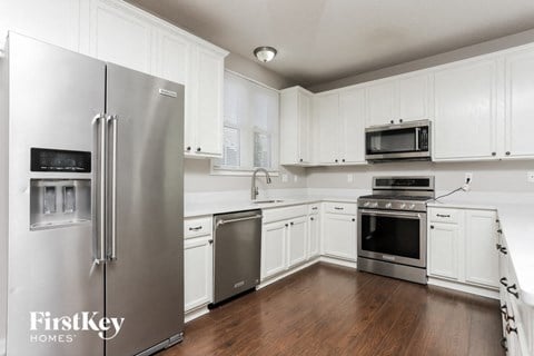 a kitchen with white cabinets and stainless steel appliances