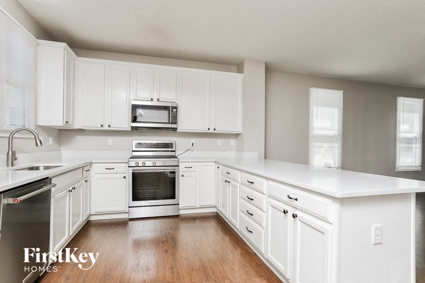a kitchen with white cabinets and stainless steel appliances