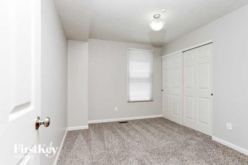 an empty room with a white door and a window