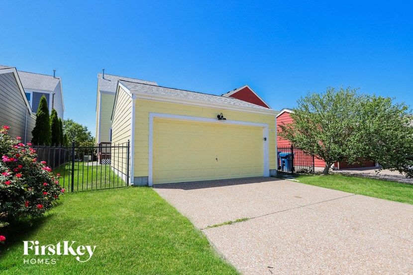 a yellow house with a driveway and a yellow garage door