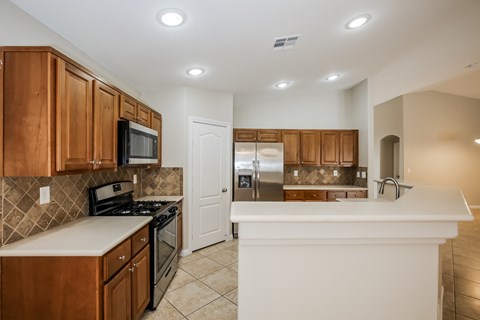 A kitchen with brown cabinets and a white island.