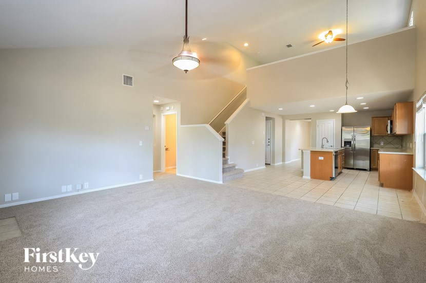 A spacious living room with a staircase leading to the upper floor.