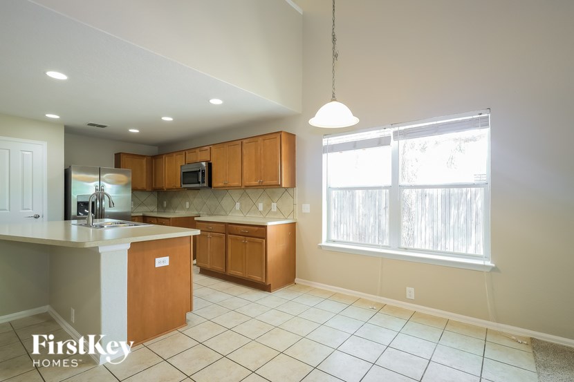 A kitchen with a sink, microwave, and cabinets.