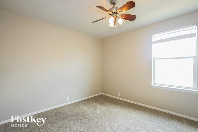 A room with a ceiling fan and a window.