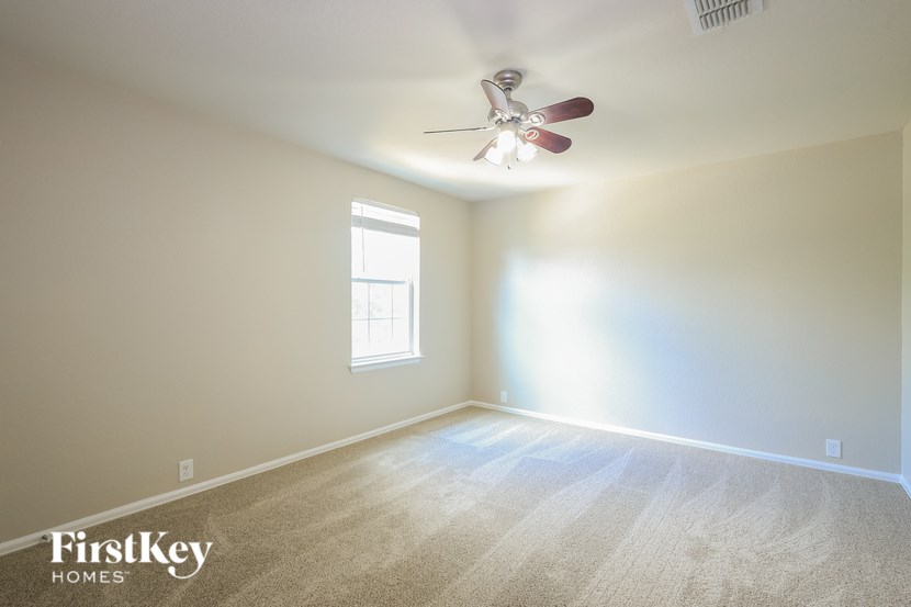 A room with a fan and a window.