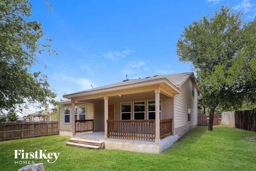 A house with a porch and a fence in the background.