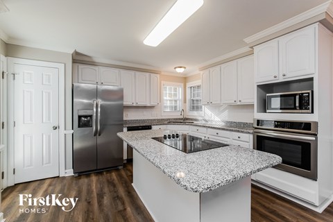 A kitchen with a granite countertop and stainless steel appliances.