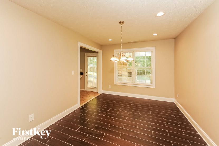 a empty living room with a chandelier and a window